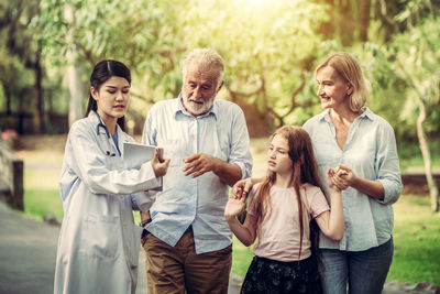 Group of people looking away while standing on smart phone