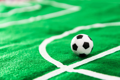 Close-up of small soccer ball on green textile