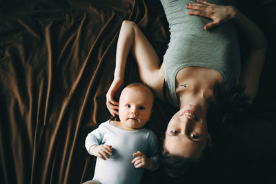 Mother and son lying down on textile