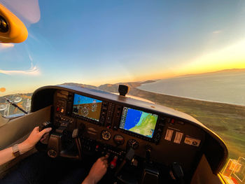 Man photographing airplane against sky during sunset