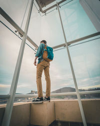 Boy standing by sea against sky