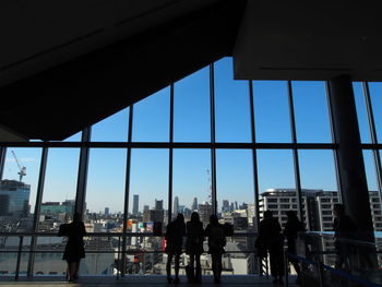 People in modern buildings against sky