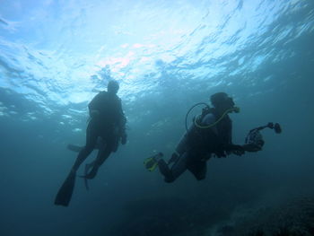 Low angle view of people swimming in sea