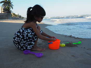 Rear view of girl with toy on beach