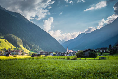 Scenic view of agricultural field by mountains against sky