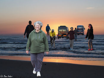 Full length of friends walking on beach during sunset