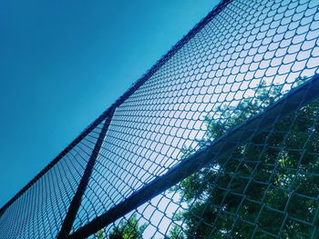 Low angle view of bridge in city against blue sky