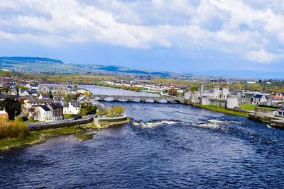 Bridge over river against buildings in city