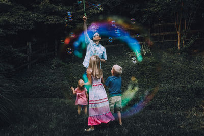 Father playing with children at park