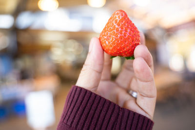 Cropped hand holding strawberry