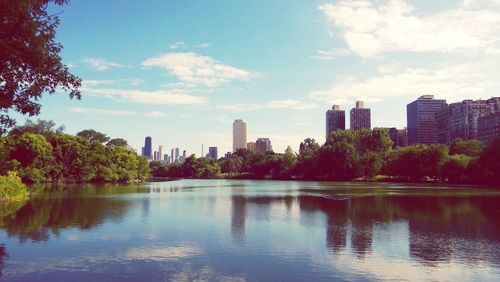 Scenic view of lake by buildings against sky