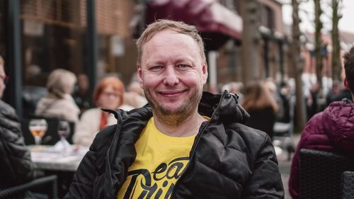 Portrait of smiling man sitting at outdoor cafe