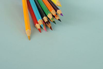 High angle view of multi colored pencils against white background