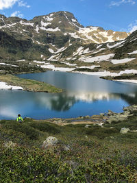 Scenic view of lake by mountains against sky