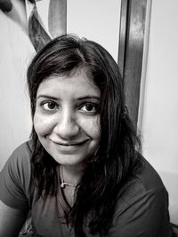 Close-up portrait of smiling young woman at home