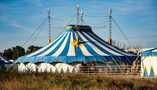 Low angle view of circus tent on field against sky