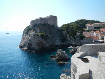 Rock formations in sea against clear sky