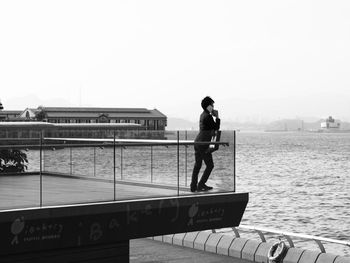 Full length of man skateboarding on railing against clear sky