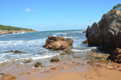 Rocks on beach against sky