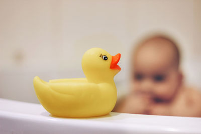 Baby boy taking a bath with yellow rubber duck