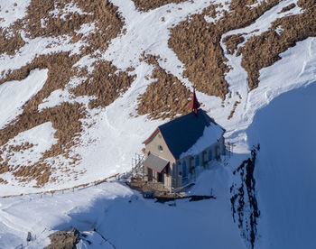 Snow covered houses by buildings against mountain