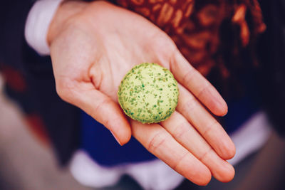 Midsection of person holding macaroon