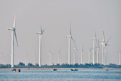 Sailboats in sea against sky