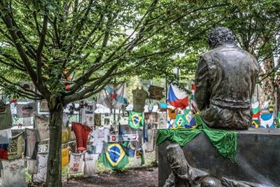 Graffiti on statue by tree in city