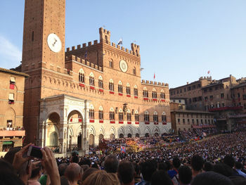 Group of people in front of buildings against sky