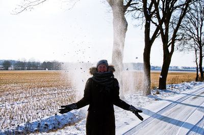 Portrait of woman standing on snow covered tree