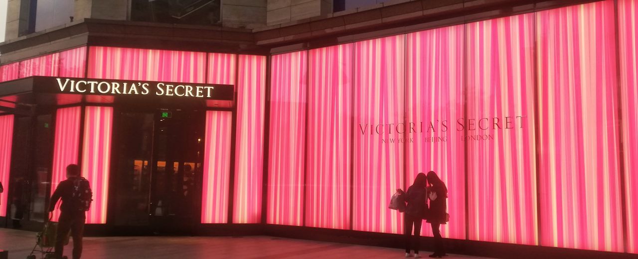 FULL LENGTH OF WOMAN WALKING WITH TEXT ON PINK WALL