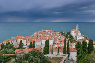 High angle view of cityscape by sea against sky
