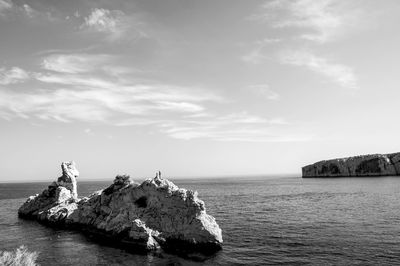 Scenic view of rock formation in sea against sky