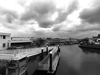 Bridge over river in city against sky