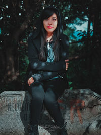 Portrait of young woman sitting outdoors