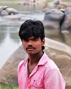 Portrait of young man against lake