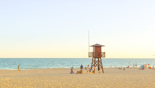 People on beach against clear sky