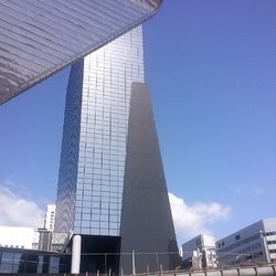 Low angle view of modern building against blue sky