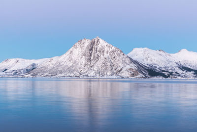 Scenic view of sea and mountains against blue sky