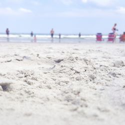 Close-up of sand at beach against sky