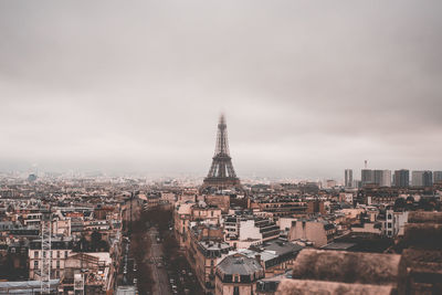 High angle view of buildings in city against cloudy sky