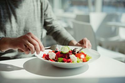 Midsection of man preparing food in plate