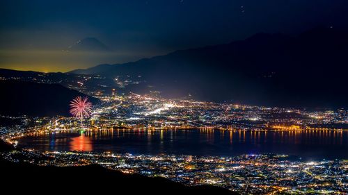 Illuminated cityscape against sky at night