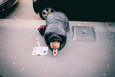 High angle view of man begging on sidewalk