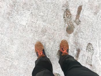 Low section of man standing on tiled floor