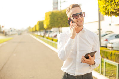 Young man using mobile phone in city