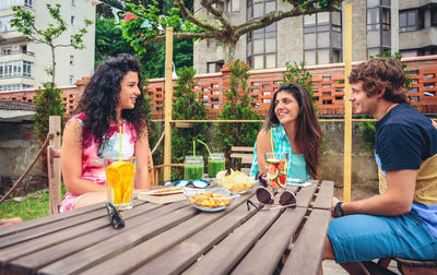 Smiling friends having food and drink at restaurant