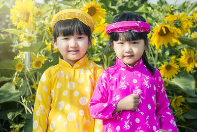 Portrait of a girl standing on yellow flowering plants