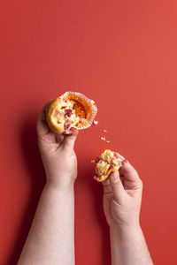 Midsection of man holding ice cream against red background