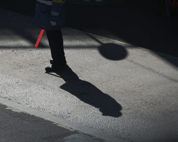 Low section of man walking on road